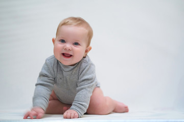 Wall Mural - a six-month-old baby learns to crawl. emotional portrait of a child