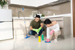 © makistock - Happy young Asian couple cleaning kitchen together