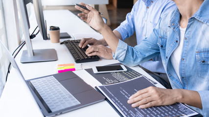 Young startup Programmers Sitting At Desks Working On Computers screen for Developing programming and coding to find solution to problem on New Application.