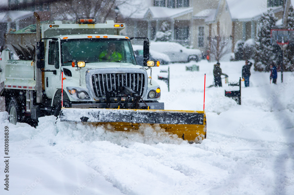Front view of city services snow plow truck with yellow blade cleaning ...