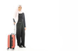 © TeTe Song - Portrait of beautiful asian muslim tourist traveller woman in a hijab holding red suitcase luggage get ready for traveling and trip and smiling isolate on white background.