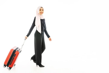 Portrait of beautiful asian muslim tourist traveller woman in a hijab holding red suitcase luggage get ready for traveling and trip and smiling isolate on white background.