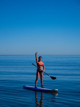 Young Asian Woman Celebrating Learning To Stand Up Paddle Board.