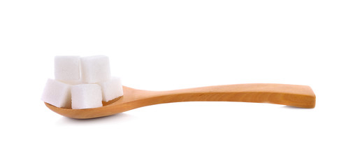 Sugar cube in wooden spoon isolated on white background