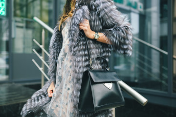 stylish woman in winter fur coat walking in street