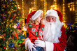 © ZaStock - Little girl whispering in Santa's ear. Telling a secret. Revealing the gift you would like to win. Talking about how she behaved during the year.