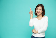 Young Elegant Asian Woman Smiling And Pointing To Empty Copy Space Isolated On Green Background