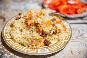 Close up plate with delicious homemade plov or pilaf with meet