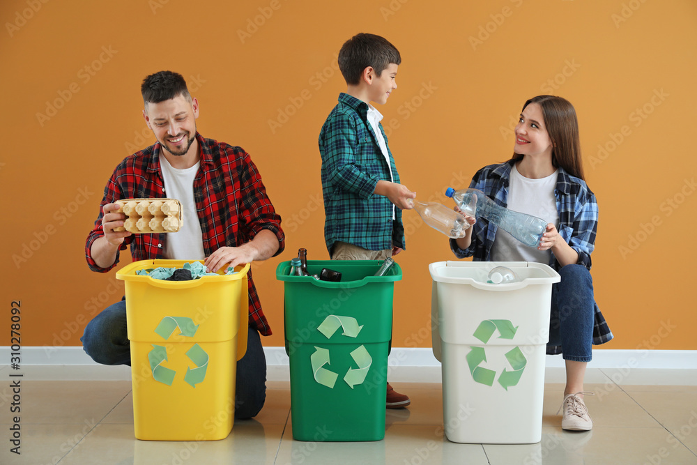 Family with containers for garbage on color background. Concept of recycling