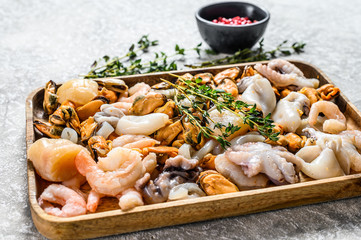 Wall Mural - Raw sea seafood cocktail in a wooden bowl. Gray background. Top view