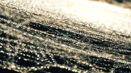Close up macro of spider web with water drops and sunset light golden rays with reflection on water. 4k abstract nature footage.