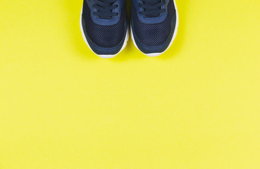 Classic blue sneakers on the yellow background. Concept for healthy lifestyle and everyday training.