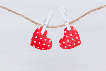 Two red hearts hanging on a thread on white wooden background. Valentine's Day, love, wedding concept. Flat lay, top view.