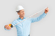 © Viktoriia - Construction. Mature man in hardhat standing isolated on white with magnetic tape measure concerned
