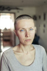 Portrait of a bald woman in a living room