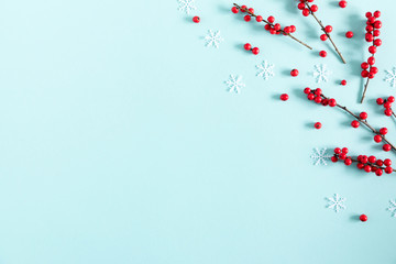 Wall Mural - christmas modern composition. red berries on pastel blue background. christmas, new year, winter con