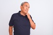 Senior grey-haired man wearing black casual polo standing over isolated white background with hand on chin thinking about question, pensive expression. Smiling with thoughtful face. Doubt concept.