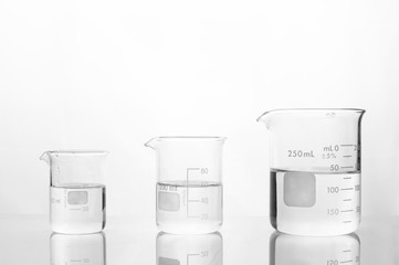 Wall Mural - three size of glass beaker with water on white medical laboratory background
