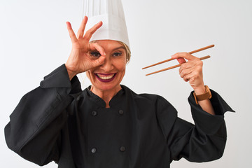 Sticker - Middle age chef woman wearing cap holding chopsticks over isolated white background with happy face smiling doing ok sign with hand on eye looking through fingers