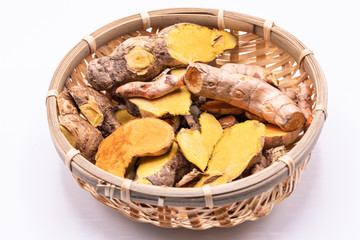 Wall Mural - Dried close up Turmeric and Cassumunar ginger roots with slices in a basket isolate on white background.(Curcuma longa Linn)