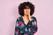 © Krakenimages.com - Young arab woman with curly hair wearing floral dress over isolated pink background touching mouth with hand with painful expression because of toothache or dental illness on teeth. Dentist concept.