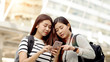 © pixs4u - Two Teenager travellers checking map on smartphone in city