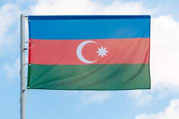 the national flag of Azerbaijan on the background of blue sky, the flag of the Azerbaijani state on a blue background