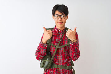 Wall Mural - Chinese hiker man wearing backpack canteen glasses over isolated white background success sign doing positive gesture with hand, thumbs up smiling and happy. Cheerful expression and winner gesture.