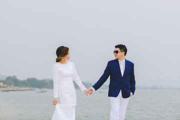 Young asian groom and bride posing and smiling for pre-wedding shot