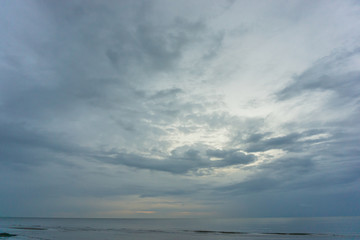 dark cloudy sky and sea. there is light shine through the cloud.