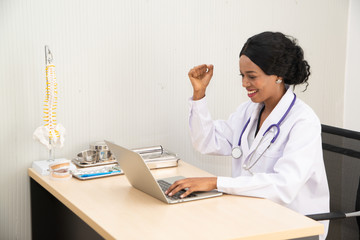 African female doctor Feeling happy that the results of the disease Patient's fever was achieved on the laptop.