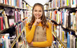 © Syda Productions - education, reading and silence concept - young teenage student girl making hush gesture over library background