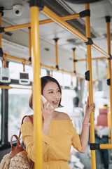 Wall Mural - Asian girl using phone on public bus