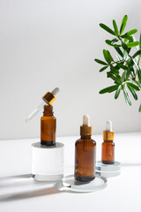 Wall Mural - natural cosmetic skincare or essential oil bottles container and green leaf on white background. hom