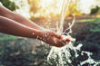 Leinwanddruck Bild - Water pouring on hand in morning ligth background
