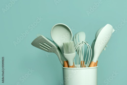 Kitchen utensils background with copyspace, home kitchen decor concept, kitchen tools, rubber accessories in container. Restaurant, cooking, culinary, kitchen theme. Silicone spatulas and brushes