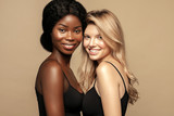  Multi Ethnic Group of Womans with diffrent types of skin  together and looking on camera. Caucasian and African ethnicity womens posing and smiling against beige background.