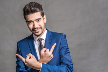 Smiling businessman in blue suit showing two middle fingers.