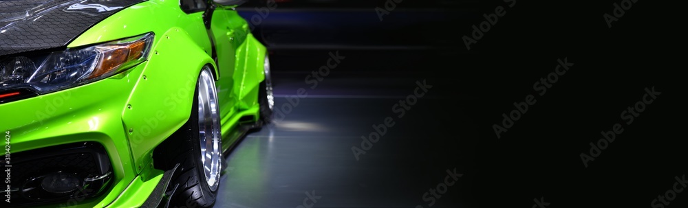 Front headlights of green modify car on black background,copy space - obrazy, fototapety, plakaty 