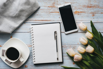Wall Mural - bouquet of tulips with an empty notebook, a Cup of coffee and a smartphone on a wooden background