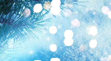 Winter christmas background. Pine branches close-up, New Year's blurry lights, snowdrift