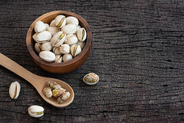 Wall Mural - Pistachio nut in wooden bowl on rusty wood table background