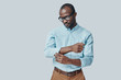 © gstockstudio - Fashionable young African man adjusting sleeve while standing against grey background