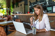 © Dragana Gordic - Smiling woman sitting in cafeteria holding coffee mug and working on laptop. Businesswoman checking email on laptop. Beautiful middle aged woman and using laptop at cafe while drinking a cup of tea.