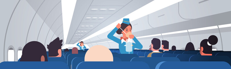 Wall Mural - stewardess explaining for passengers how to use oxygen mask in emergency situation flight attendants safety demonstration concept modern airplane board interior horizontal vector illustration