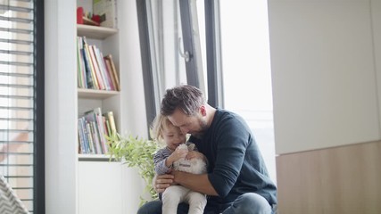 Wall Mural - Cheerful young father with small daughter indoors in bedroom playing.