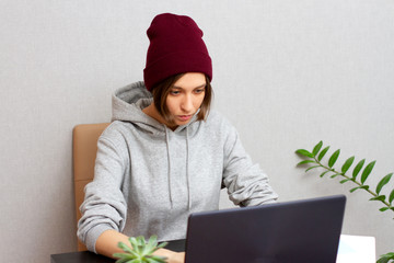 Younfg women programmer at a desk in the office working at a laptop