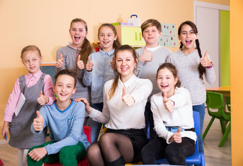 Wall Mural - Pupils with teacher giving thumbs up in schoolroom