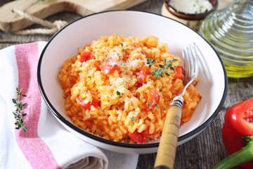 Italian food. Plate of red bell pepper risotto, olive oil and parmesan cheese