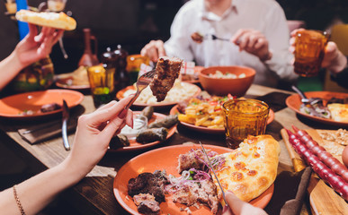 View from above of georgian cuisine on brown wooden table.Traditional georgian food-khinkali,kharcho,chahokhbili,phali,lobio and local sauces - tkemali, satsebeli, adzhika.Top view.Copy space for text